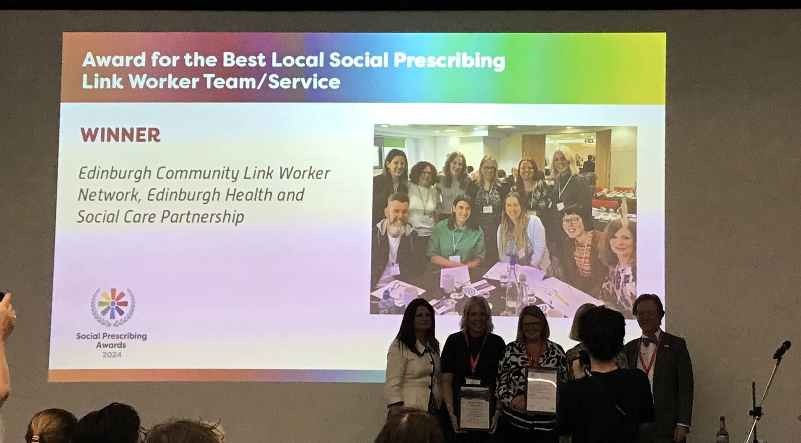 Group of individuals from the Edinburgh Community Link Worker Network accepting the 'Award for the Best Local Social Prescribing Link Worker/Service' at the Social Prescribing Awards 2024.